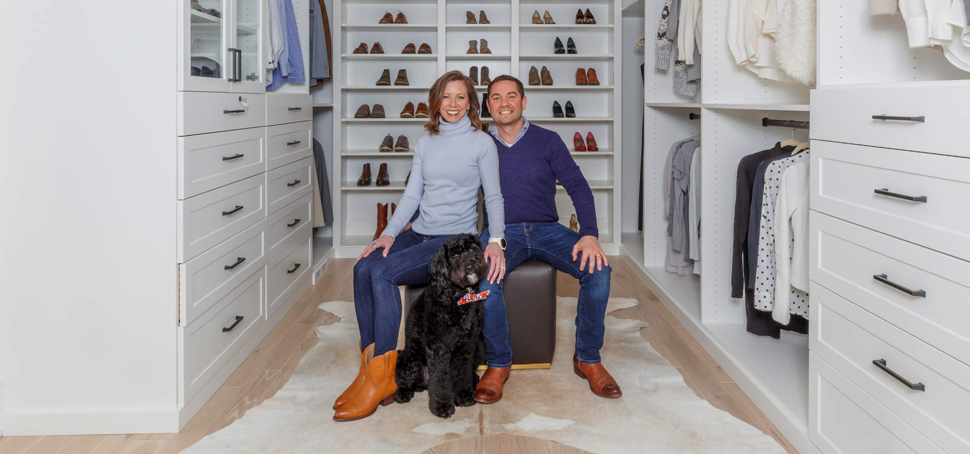happy couple sitting in walk-in closet